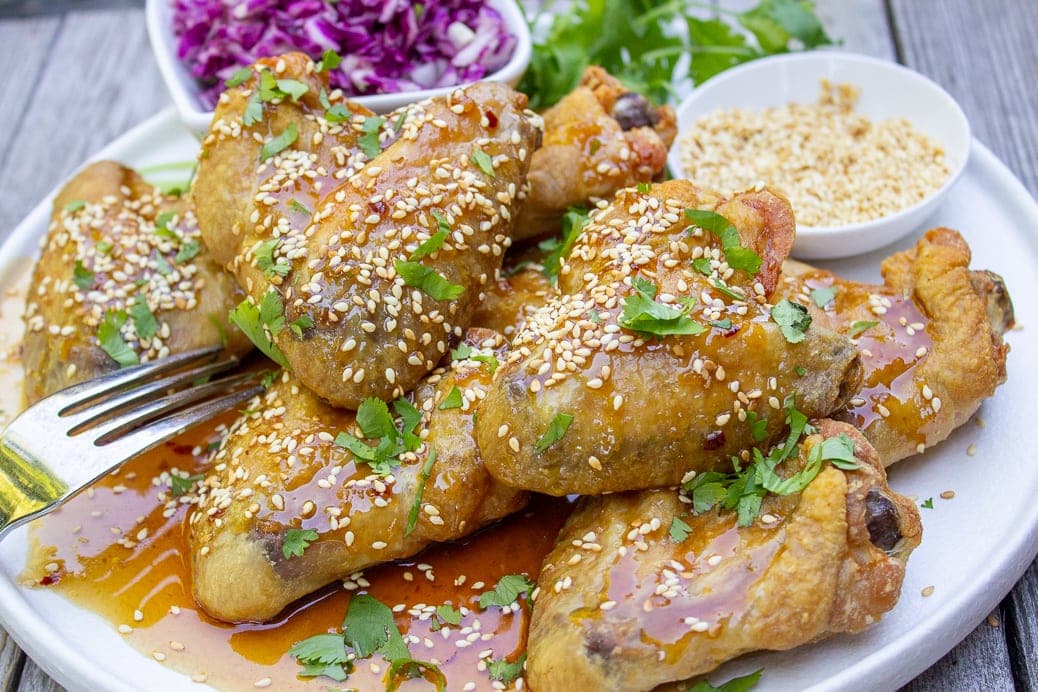 baked chicken wings with honey garlic sauce garnished with sesame seeds on plate