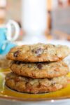 3 Skor chocolate chip cookies stacked on saucer in front of teacup p1