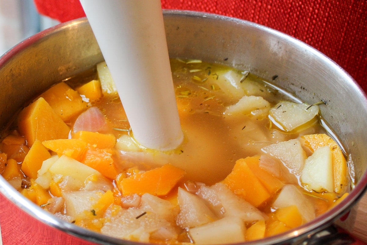 butternut squash soup in pot with immersion blender