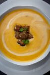 bowl of butternut squash soup on plate p