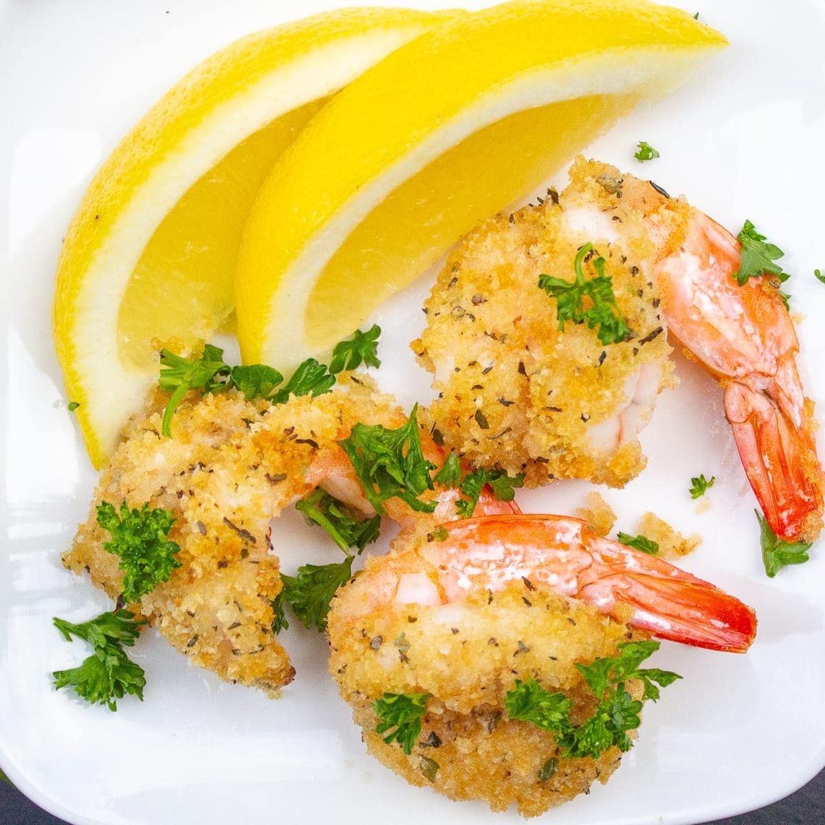 3 breaded butterflied shrimp on plate with lemon 3