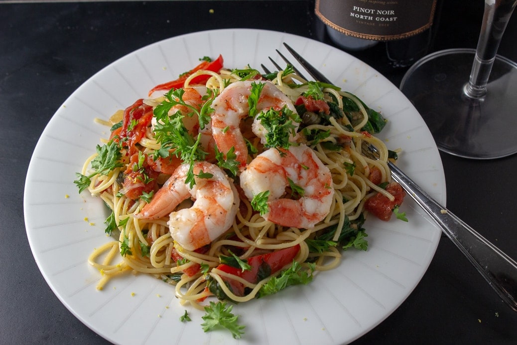 vegetable pasta on plate topped with shrimp