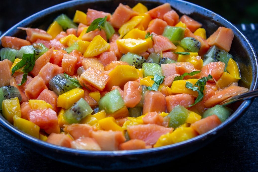Fruit Salad with kiwi manago papaya mint and orange juice in bowl