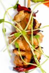 skewer of peanut chicken garnished with pea shoots