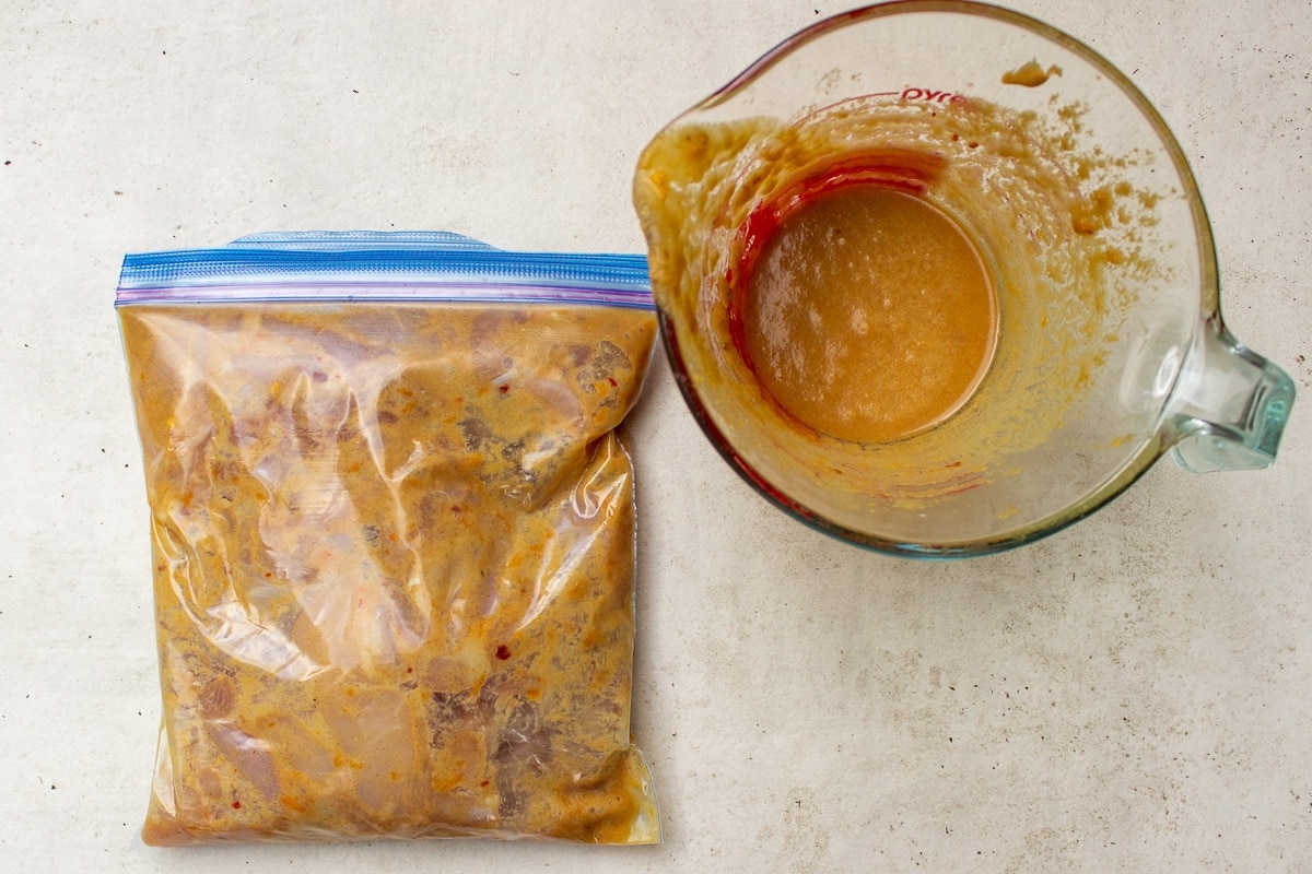peanut sauce in cup and bag of chicken mariniating