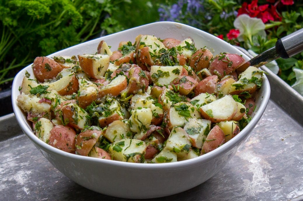 Herb Potato Salad in bowl on tray in garden