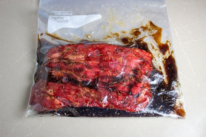 flank steak marinating in ziploc bag