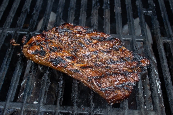 flank steak on grill with grill marks