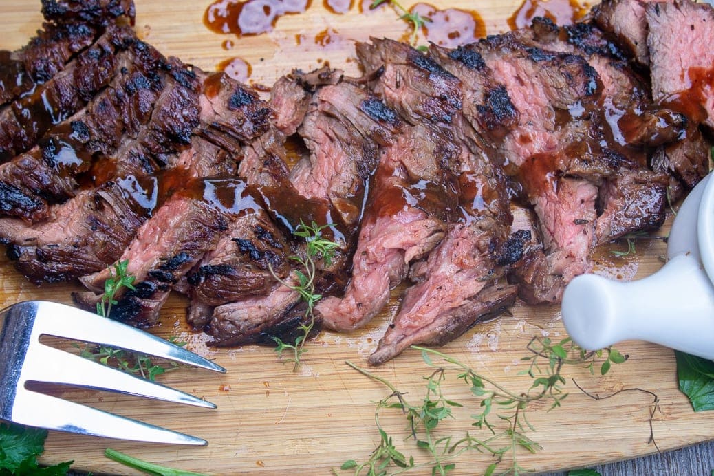 sliced marinated flank steak on cutting board