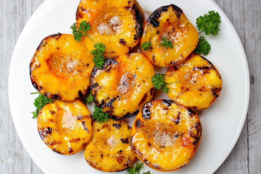 grilled peach halves on a plate f