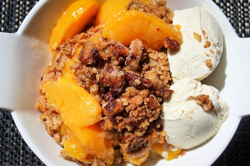 Peach Crumble in a bowl with vanilla ice cream 1
