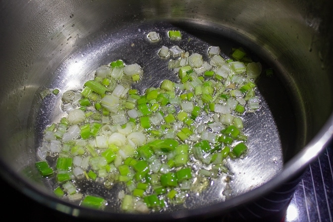 chopped green onions sauteing in sauce pan with oil