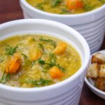 two bowls of split pea soup with croutons