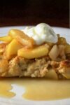 piece of apple french toast casserole on plate with sour cream on top