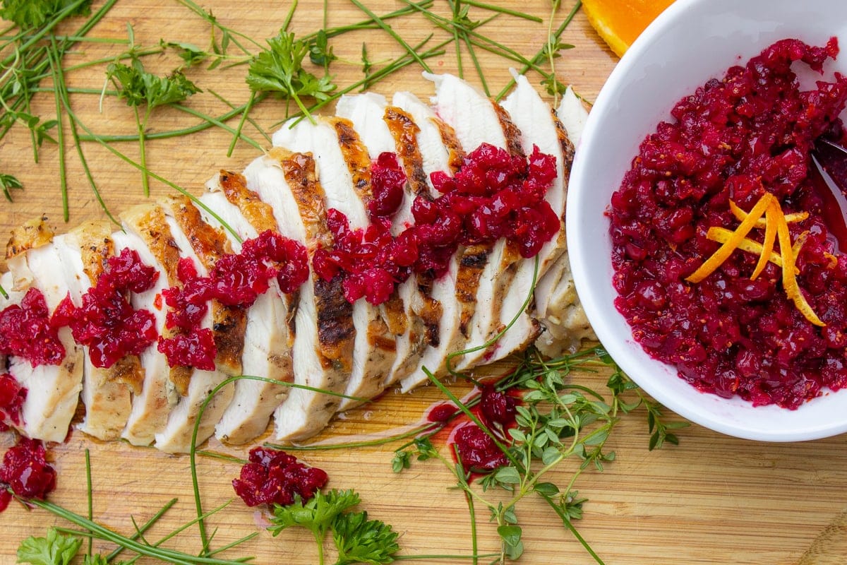 Cranberry-Orange Relish in bowl and spoon over sliced turkey breast f