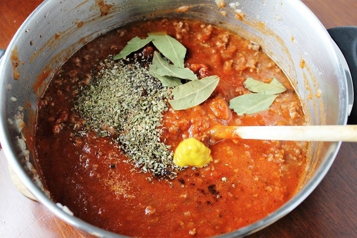 meat sauce in pot with seasonings added