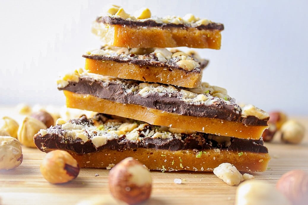 Chocolate toffee stacked on board with hazelnuts