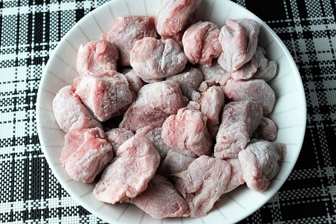 veal cubes lightly coated with flour in bowl