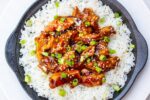 bourbon chicken over rice on plate f