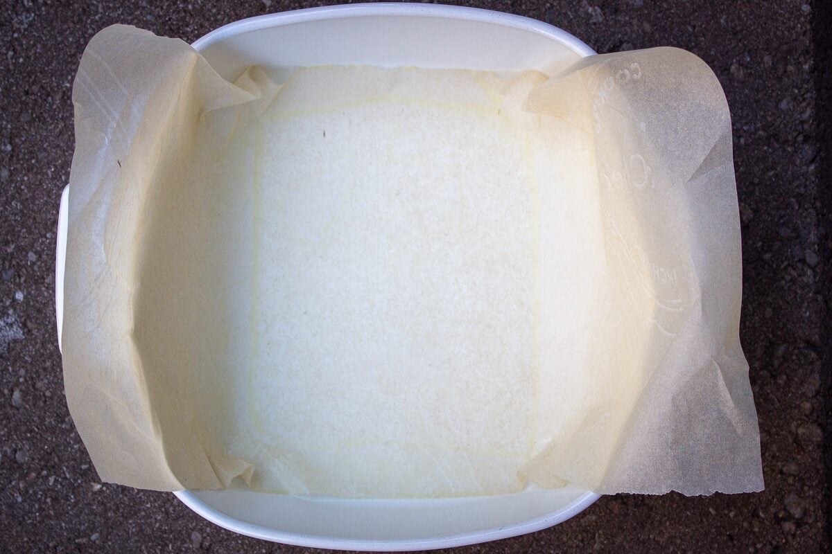 pan lined with parchment hanging over the sides