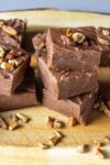 pieces of easy chocolate fudge on serving board with nuts on top p1