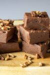 pieces of easy chocolate fudge on serving board with nuts on top p2