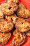 elephant ears pastries (palmier cookies) on a red plate p