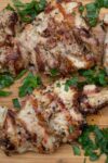 Mediterranean marinated grilled chicken on cutting board with parsley p1