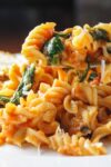 tomato spinach pasta on plate with bread p