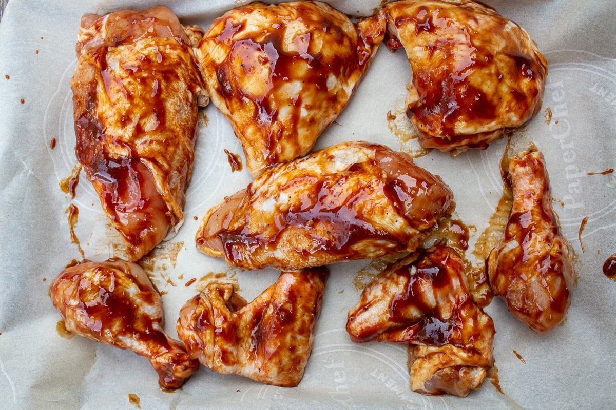 Balsamic glazed chicken pieces on plate before cooking