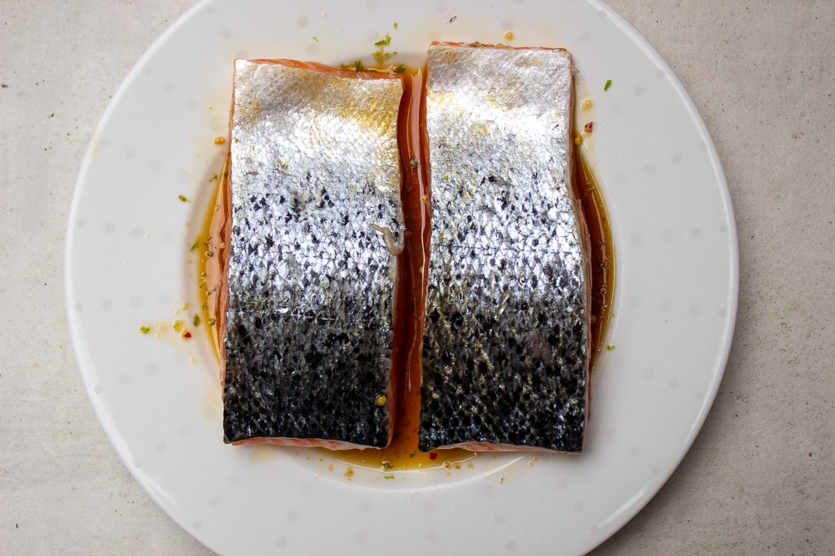 salmon filets marinating on plate