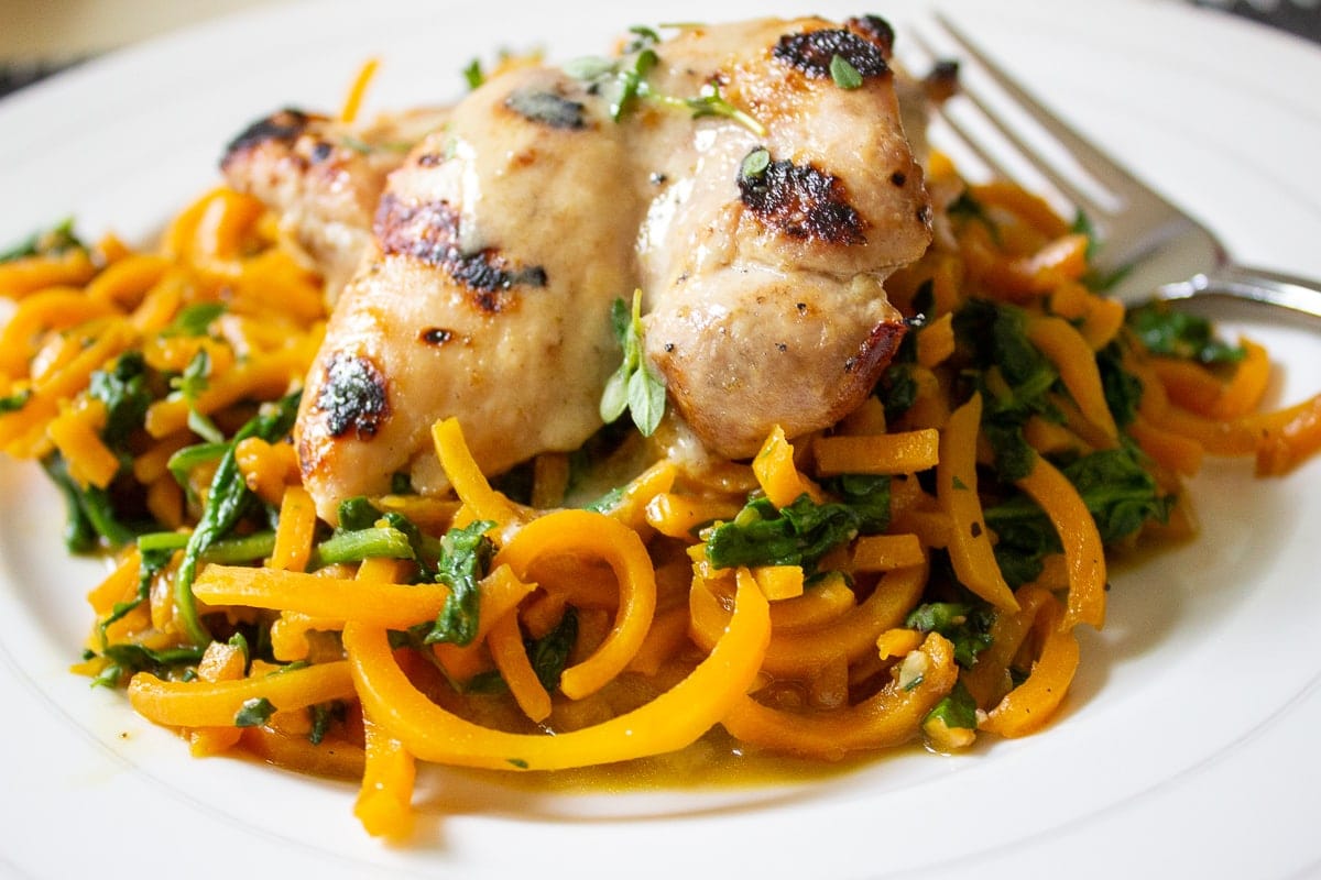 chicken on top of butternut squash noodles in bowl 