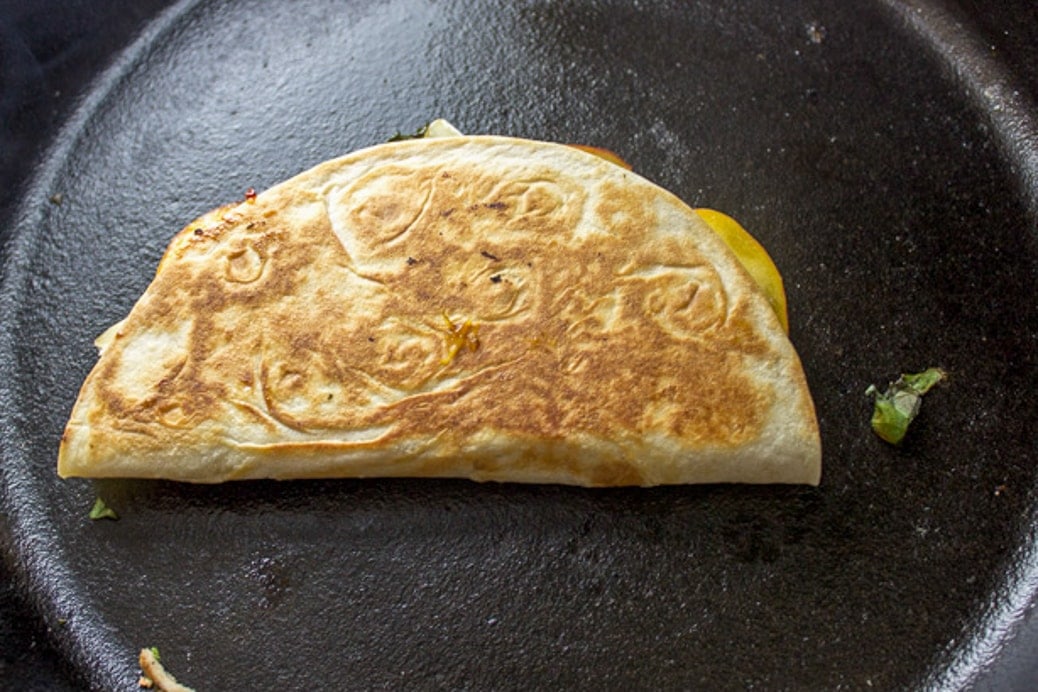 moon shaped quesadilla cooking in pan