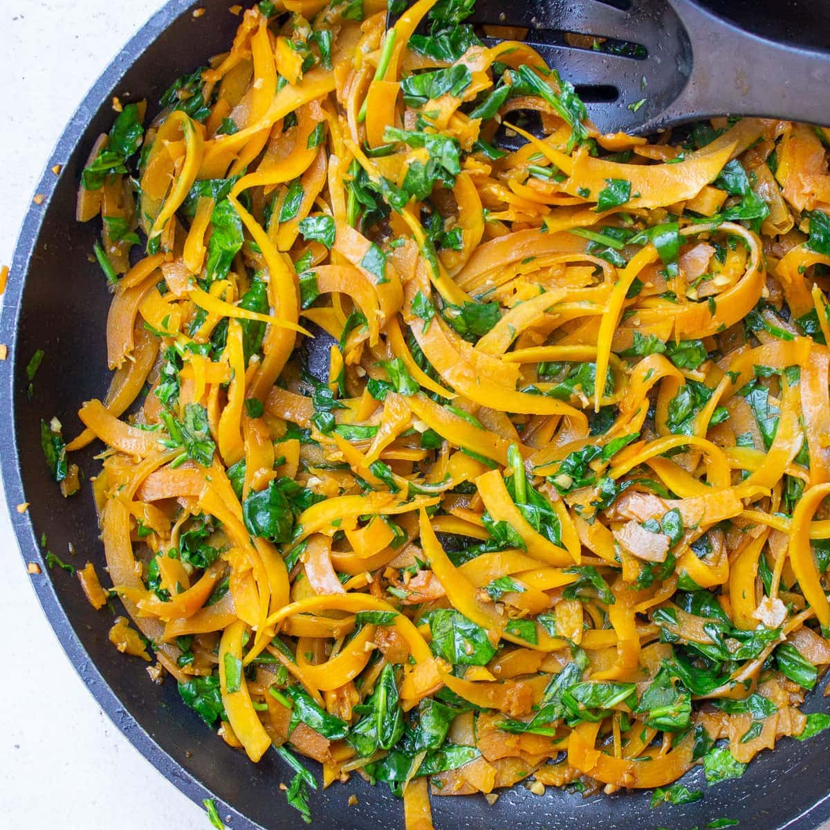 sauteed butternut squash noodles in pan with spinach f
