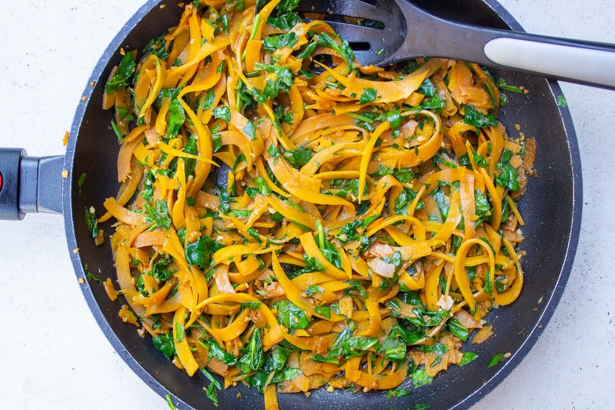 sauteed butternut squash noodles in pan with spinach