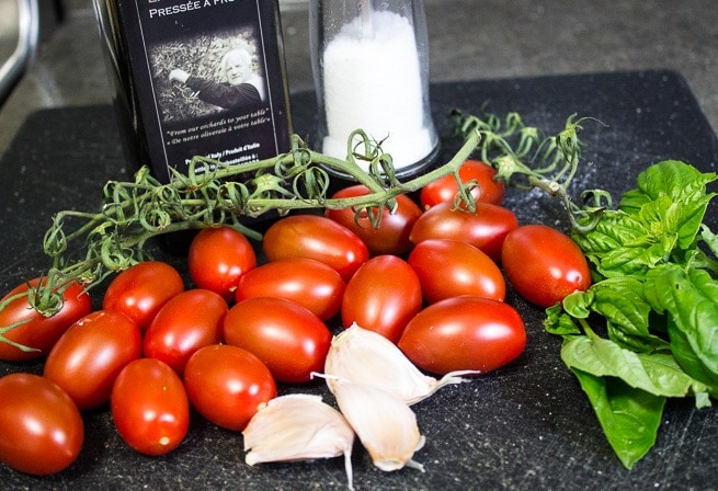 tomatoes, salt pepper, garlic oil on cutting board