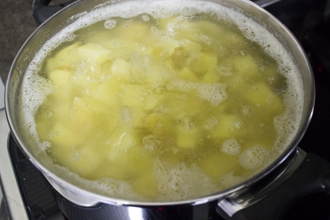 cube potatoes in pot boiling