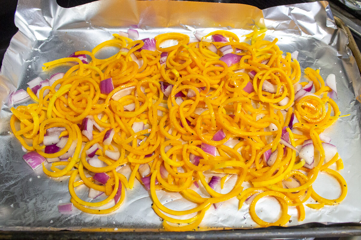 Spiralized squash and onions on pan.