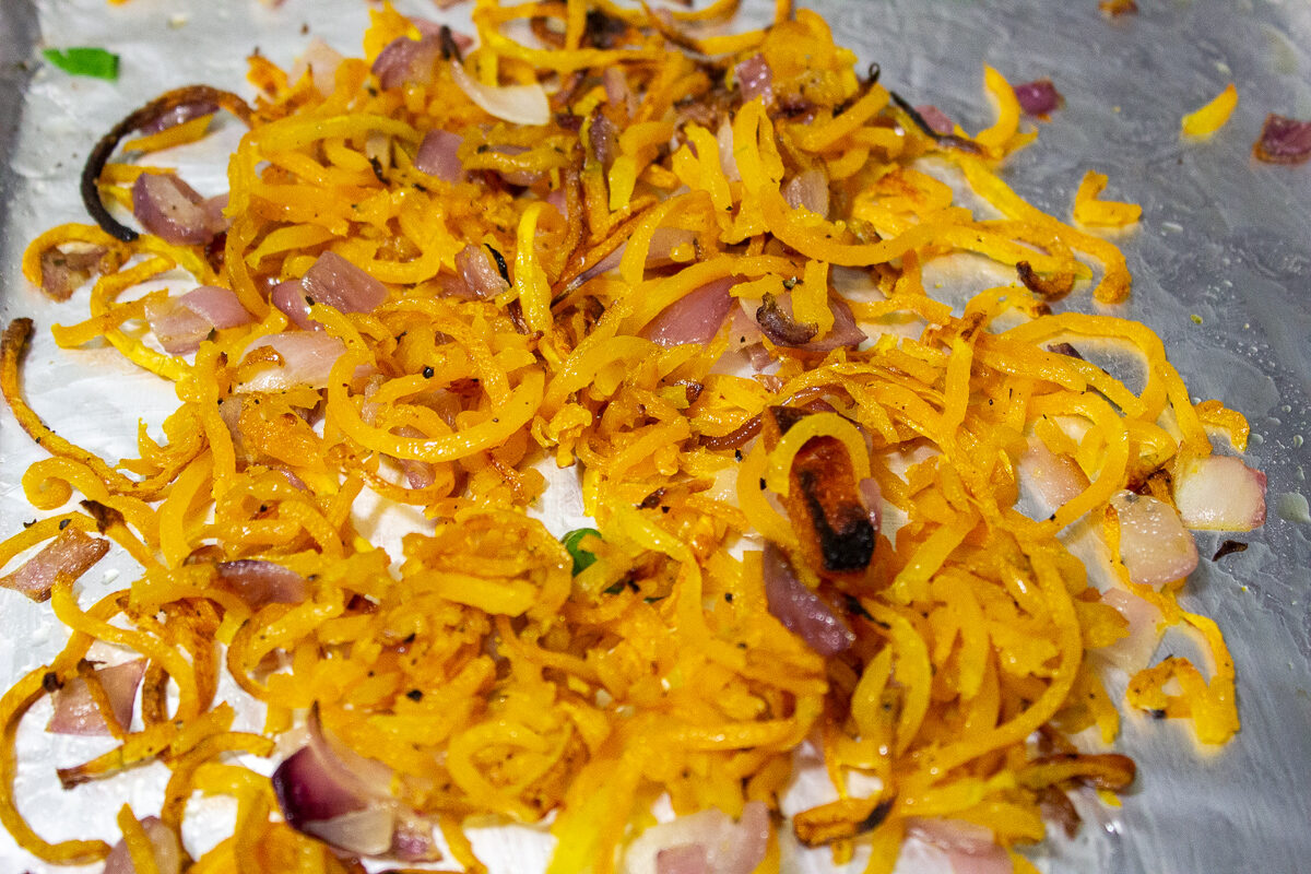 Roasted squash and onions on pan.