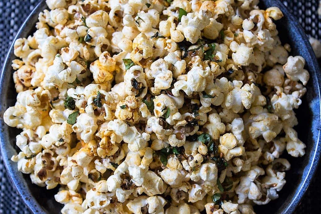 Spiced herb popcorn in bowl close up