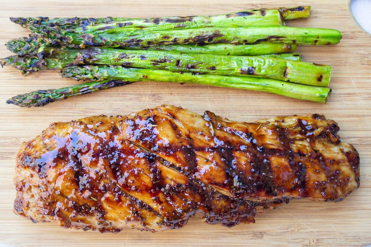 glazed pork tenderloin with asparagus on cutting board