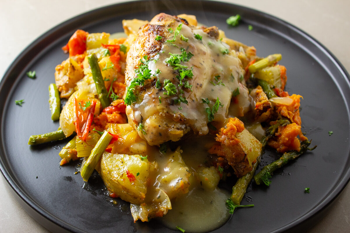 chicken and roasted veggies on plate with gravy 2