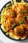 chicken meatballs in paprikash sauce over noodles on plate p
