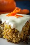 piece of carrot and pineapple cake with cream cheese icing on a plate