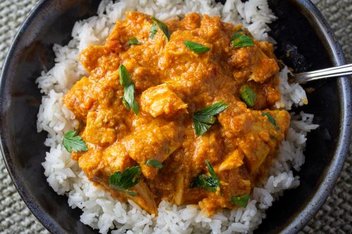 butter chicken over rice in bowl 1