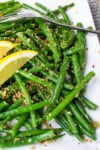 green beans with lemon garlic panko on a plate with lemon wedges p1