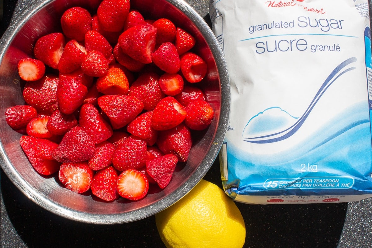 bowl of strawberries, lemon, sugar