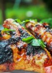 two Grilled Chili Lime Chicken Wings on cutting board with garden in background p