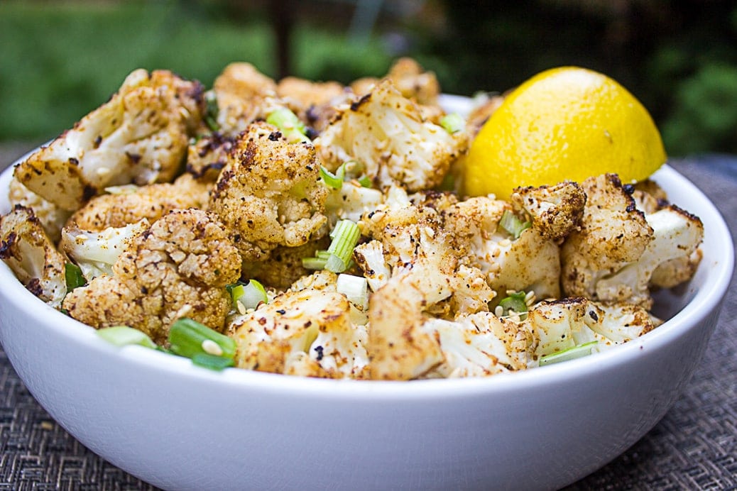 Grilled Spiced Cauliflower in a bowl with a lemon wedge