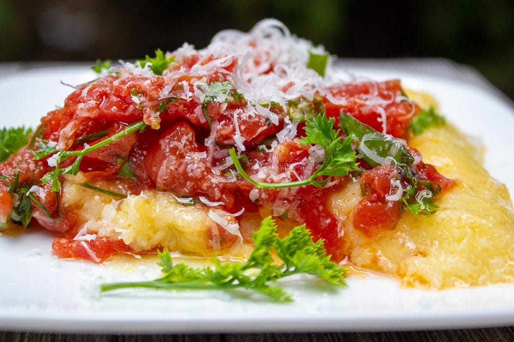 plate of polenta topped with tomato herb salad f